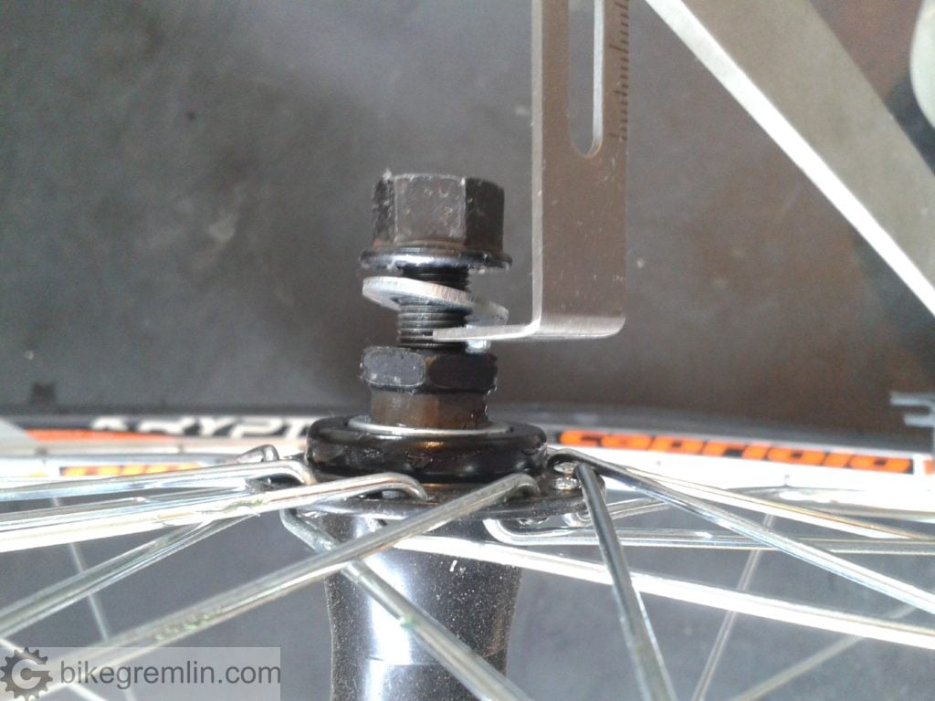 Slight hub off-center. The ruler exaggerates the error (doubling it), so it's not as bad as it seems. However, since some spokes needed tightening and the wheel needed truing anyway, this error was also fixed.