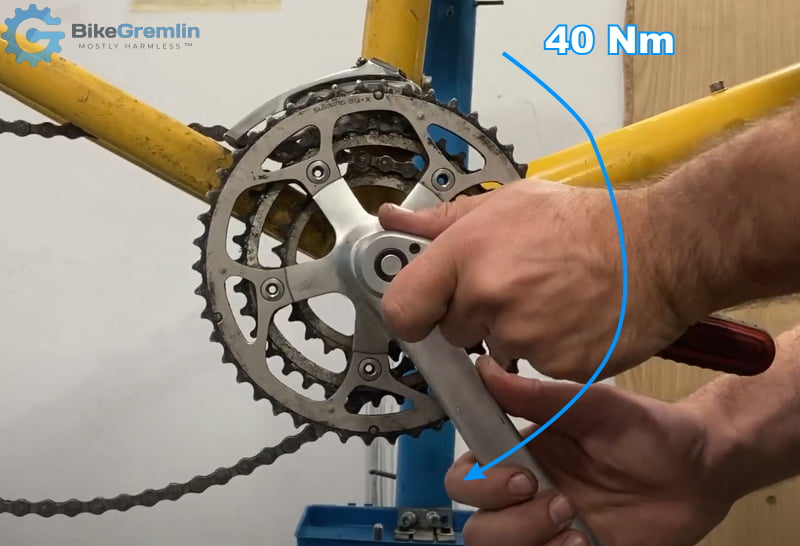 Slide the crank over the spindle, thread in the tightening bolt by hand, and tighten it to 40 Nm